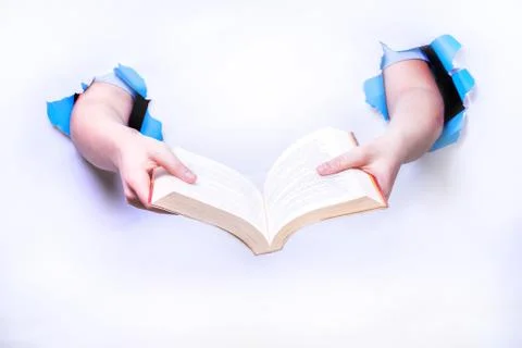 Hands coming out of a white background holding a book. Stock Photos