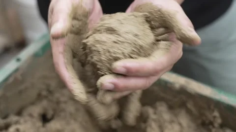 Hands Compressing Damp Earth into a Rough Ball Stock Footage 340901016