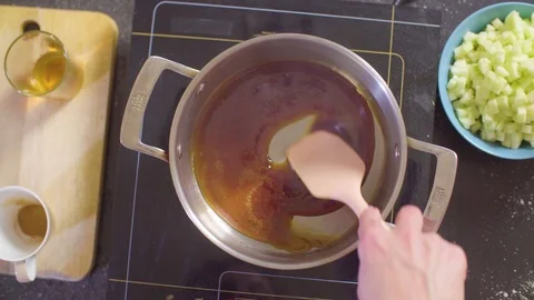 Hands of a confectioner adding apples to melted sugar Stock Footage 98047117