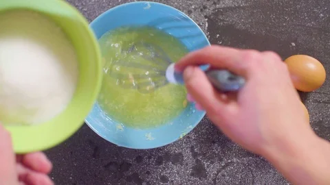 Hands of a confectioner adding sugar and eggs to lemon juice Stock Footage 98045906