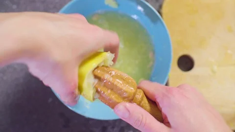 Hands of a confectioner squeezing juice from lemons Stock Footage 98045589