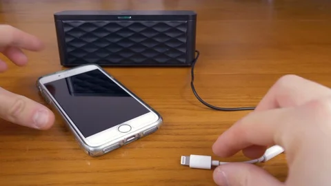 Hands that connect the audio cable to the smartphone Stock Footage 87198520