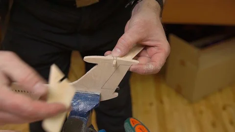 Hands connect tail unit planes with fuselage fixed in vice Stock Footage 127113016