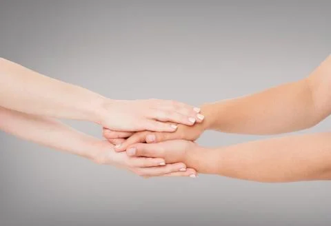 Hands connected together on grey background - concept of united team Stock Photos