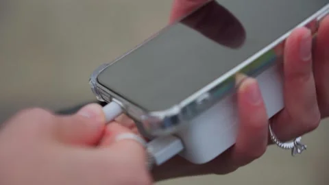 Hands connecting mobile phone to solar power bank closeup Stock Footage 242879455