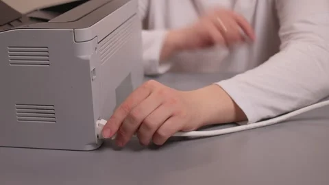 Hands connecting printer. Plugging in printer cable steps. Closeup of hands Stockbeeldmateriaal 347880374