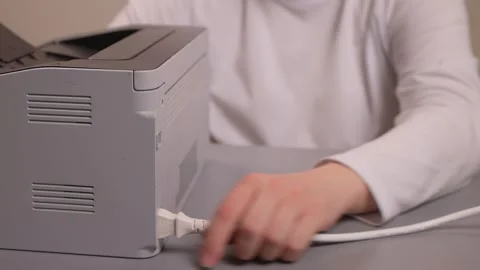Hands connecting printer. Plugging in printer cable steps. Closeup of hands Stockbeeldmateriaal 347880379