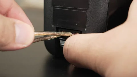 Hands Connecting Speaker Wire to Rear Terminals on Black Bookshelf Speaker Stock Footage 340579005