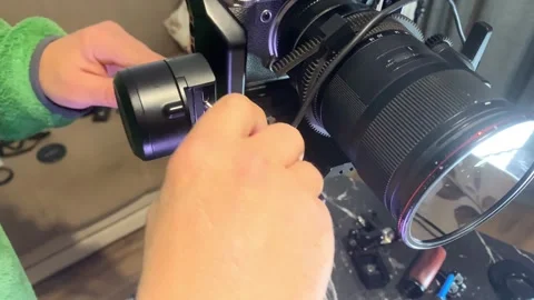 Hands connecting USB-C cable to camera stabilizer close-up, installing manual Stock Footage 333649536