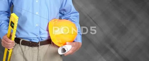 Hands of construction worker with helmet and level. Stock Photos