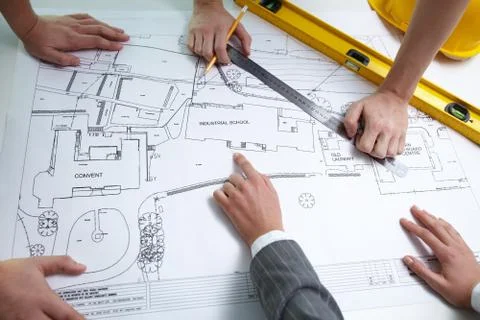 Hands of constructors over architectural project Stock Photos