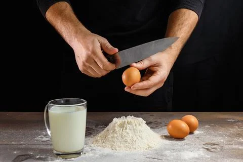Hands of the cook close-up, breaks the egg into flour, a glass of fresh milk, Stock Photos
