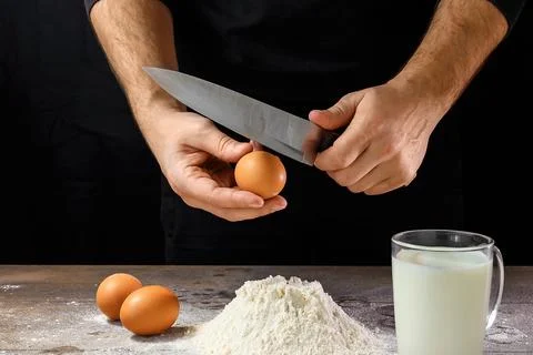 Hands of the cook close-up, breaks the egg into flour, a glass of fresh milk, Stock Photos