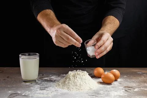 Hands of the cook close-up, breaks the egg into flour, a glass of fresh milk, Stock Photos
