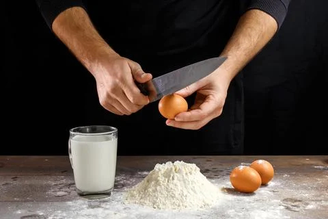 Hands of the cook close-up, breaks the egg into flour, a glass of fresh milk, Stock Photos