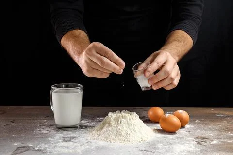 Hands of the cook close-up, breaks the egg into flour, a glass of fresh milk, Stock Photos