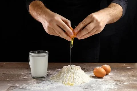 Hands of the cook close-up, breaks the egg into flour, a glass of fresh milk, Stock Photos