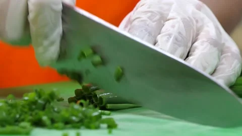 Hands of a cook cutting green vegetable with a knife. Video stock 154727392
