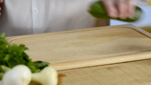 Hands of the cook knife big kitchen a fresh green cucumber on a chopping board Stock Footage 79310129