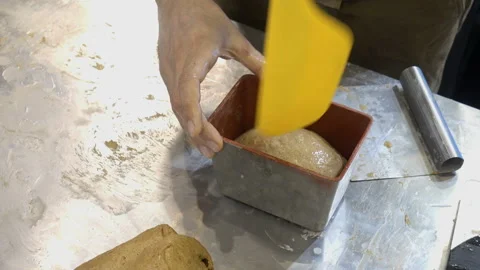 The hands of the cook put the dough into a baking dish Stock Footage 147654241