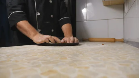 Hands of cook putting dough in the form for pizza on a wooden surface at cuisine Stock Footage 305232876