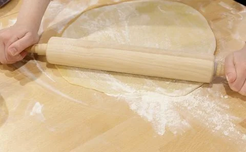 The hands of the cook roll out the thin dough. concept of making pizza or baking Foto stock