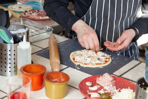 Hands of a cook sequentially preparing Italian pizza Stock Photos