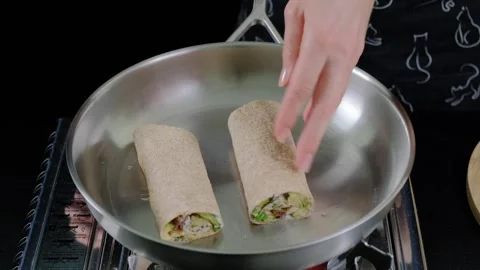 Hands Cooking Filled Crepe Rolls in Pan at Cooking Location Video stock 341421336