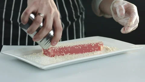 The hands of the cooks flip the tuna fillet on a white plate Stock Footage 86284285