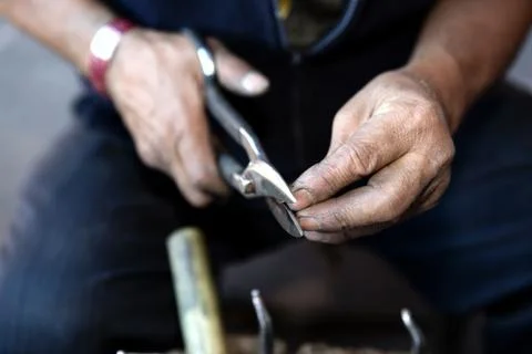 Hands of a coppersmith Stock Photos