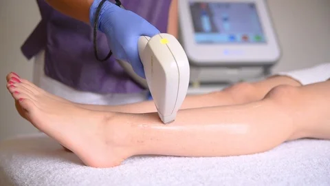 The hands of the cosmetologist make the epilation of the legs. Stock Footage 107984232