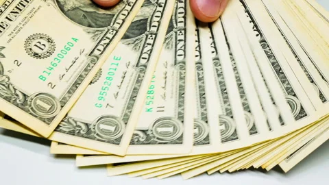 Hands count dollar banknotes. Male hands counting a stack of one-dollar US Stock Footage 246878308
