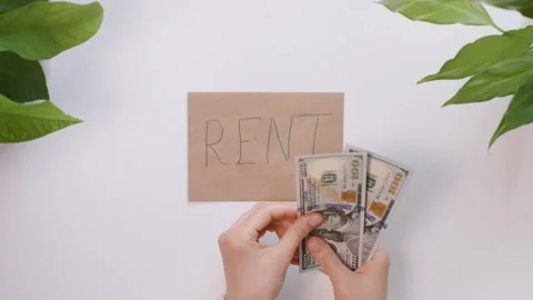 Hands count dollars and then put it on an envelope with an inscription Rent. Stock Footage 130904573