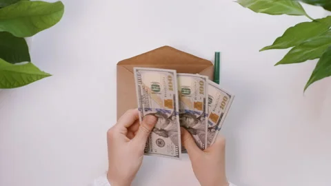 Hands count dollars and then put it in an envelope. Girl writes the Vacation. Stock Footage 130905722