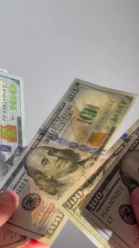 Hands count one hundred dollar bills against neutral background. Cash distr.. Stock Footage 329508876