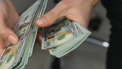 Hands Count Stacks of Hundred Dollar Bills with Precision and Care, Symbolizing Stock Footage 317025432