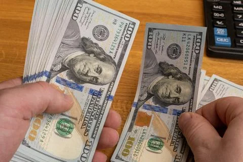Hands counting 100 US dollar banknotes on office desk close up Stock Photos