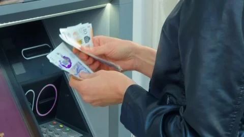 Hands counting banknotes at ATM, unrecognizable person withdrawing cash in urban Stock Footage 333245789