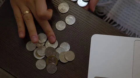 Hands counting coins on table near laptop Stock Footage 341767581