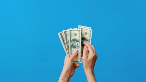 Hands counting dollar bills on blue background Stock Footage 128306618