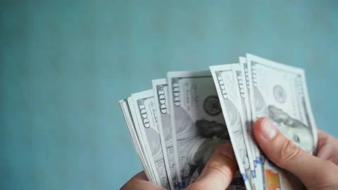 Hands counting dollars close-up on a blurred blue background. Account of a stack Stock Footage 230766303