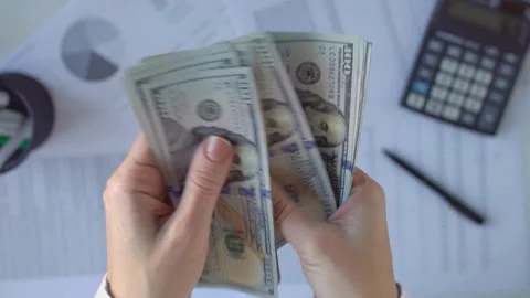 Hands counting hundred dollar bills on desk Video stock 333839046