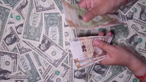 Hands counting Peruvian soles against a background of US dollars Stock Footage 318098294