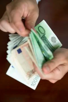 Hands counting stack of cash 写真素材