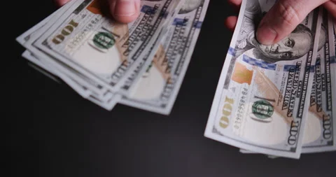 Hands counting a stack of hundred-dollar US banknotes Stock Footage 205041725