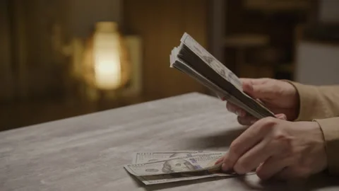 Hands counting stack of US dollar bills on table Stock Footage 302473926
