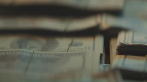 Hands counting stacks of 100 dollar bills in dim light. Video stock 344996947