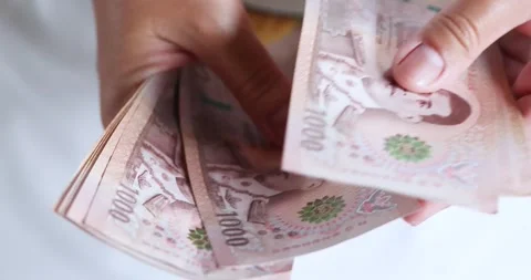 Hands counting Thai 1000 baht banknotes representing finance, money, cash Video stock 335576246