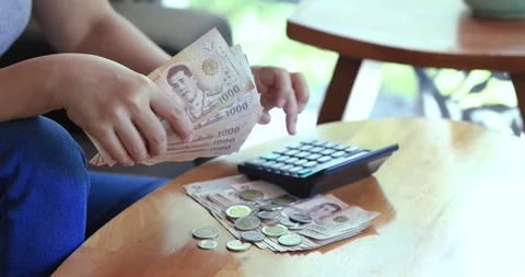 Hands counting Thai banknotes while using a calculator, budgeting, personal.. Stock Footage 340614830