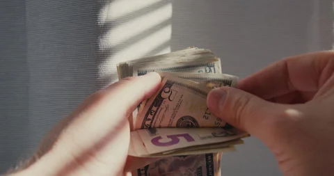 Hands counting a thick stack of dollar bills Stock-Footage 347010155